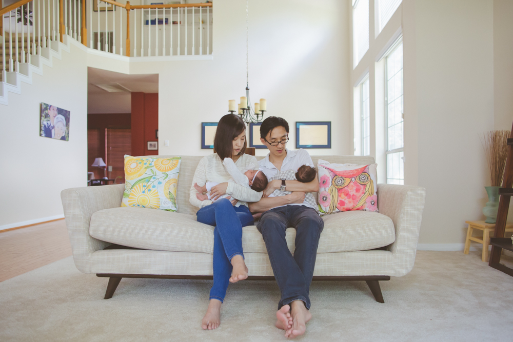 parents holding twins in living room