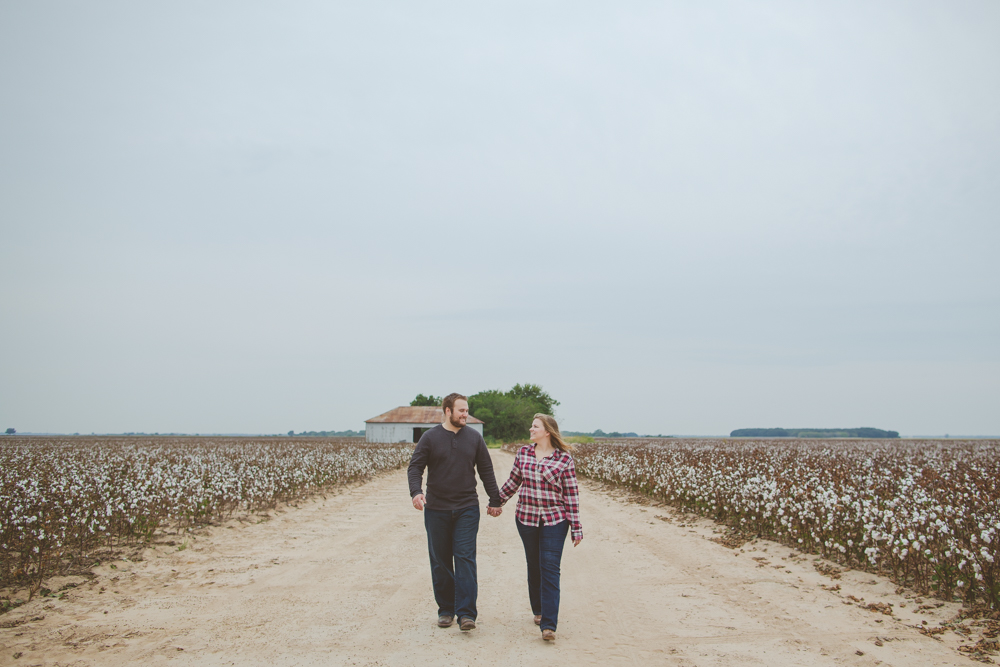couple walking in cotton field