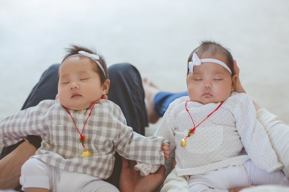 sleeping twins wearing necklaces