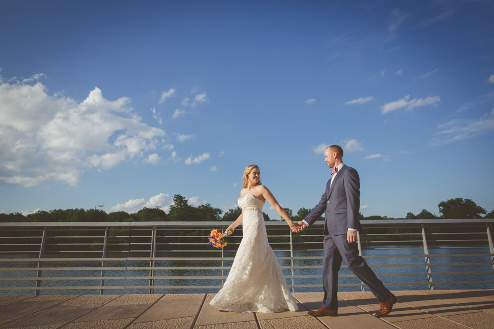 bride and groom walking on austin boardwalk