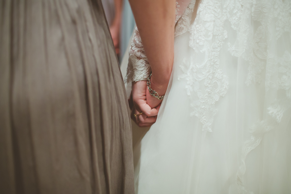bride and bridesmaid holding hands