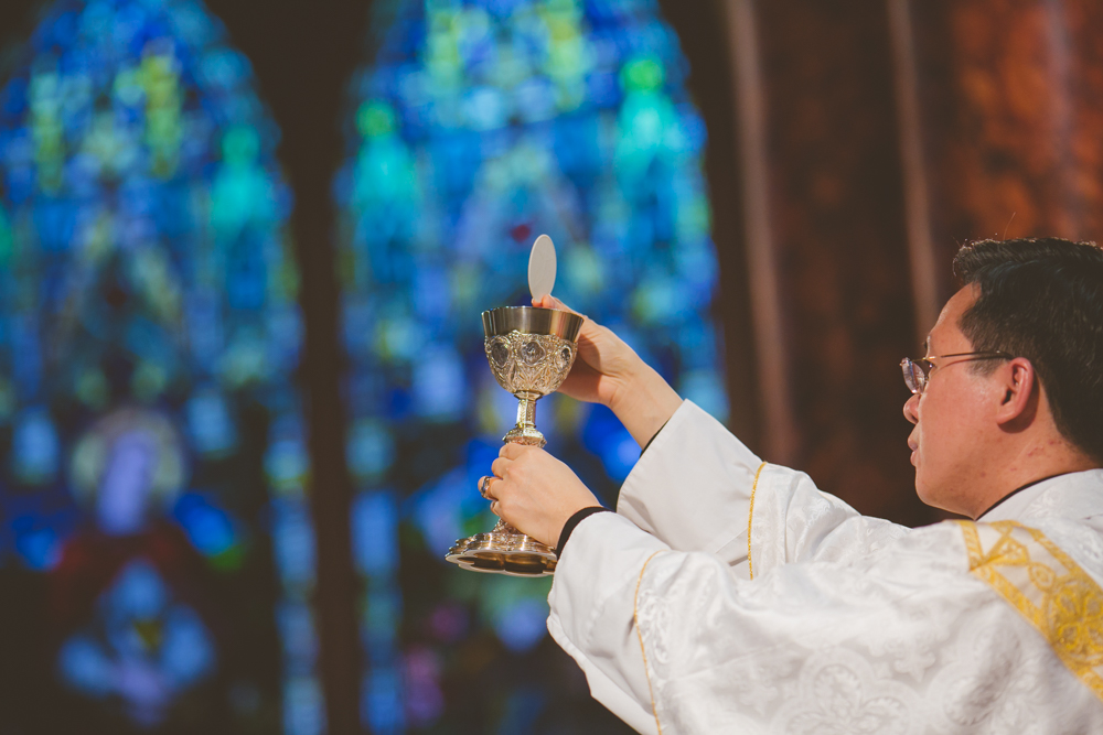 priest holding up the eucharist