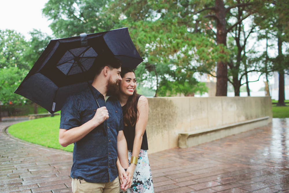 Couple cuddling under umbrella
