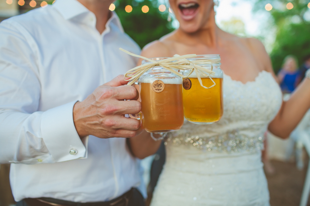 bride and groom holding custom mason jars