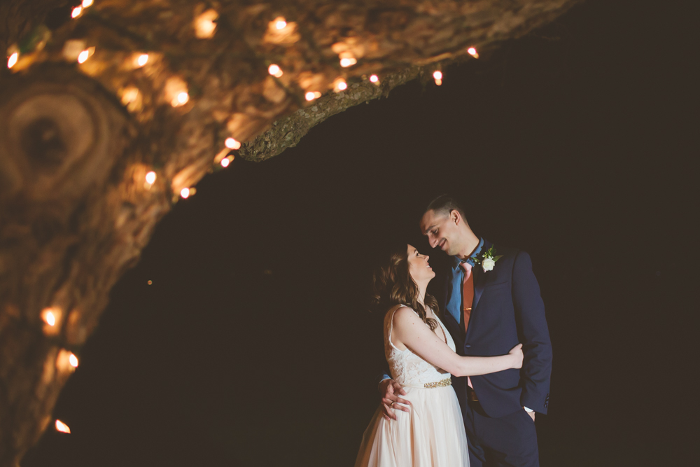 bride and groom under twinkle lights
