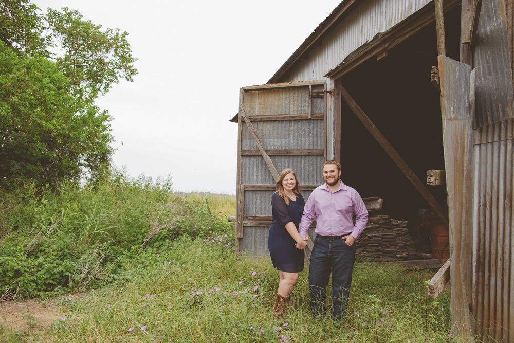 couple standing by a barn