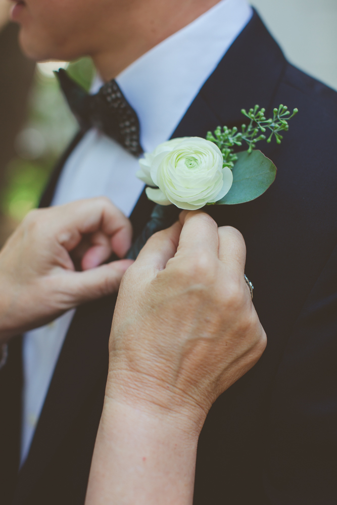 pinning groom's boutonniere
