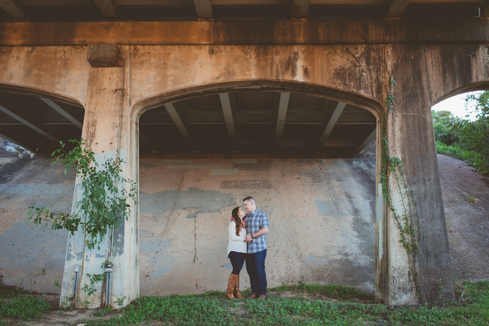 couple standing under a bridge