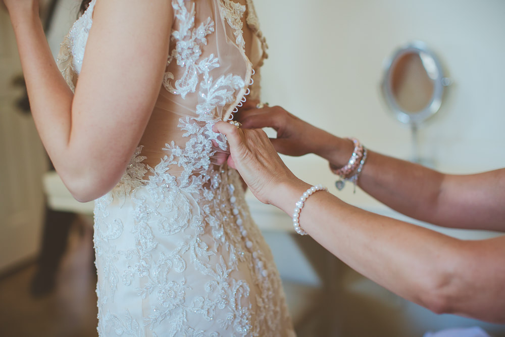 bride buttoning up dress