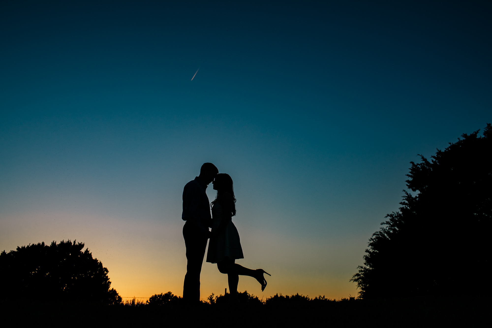 sunset silhouette of engaged couple