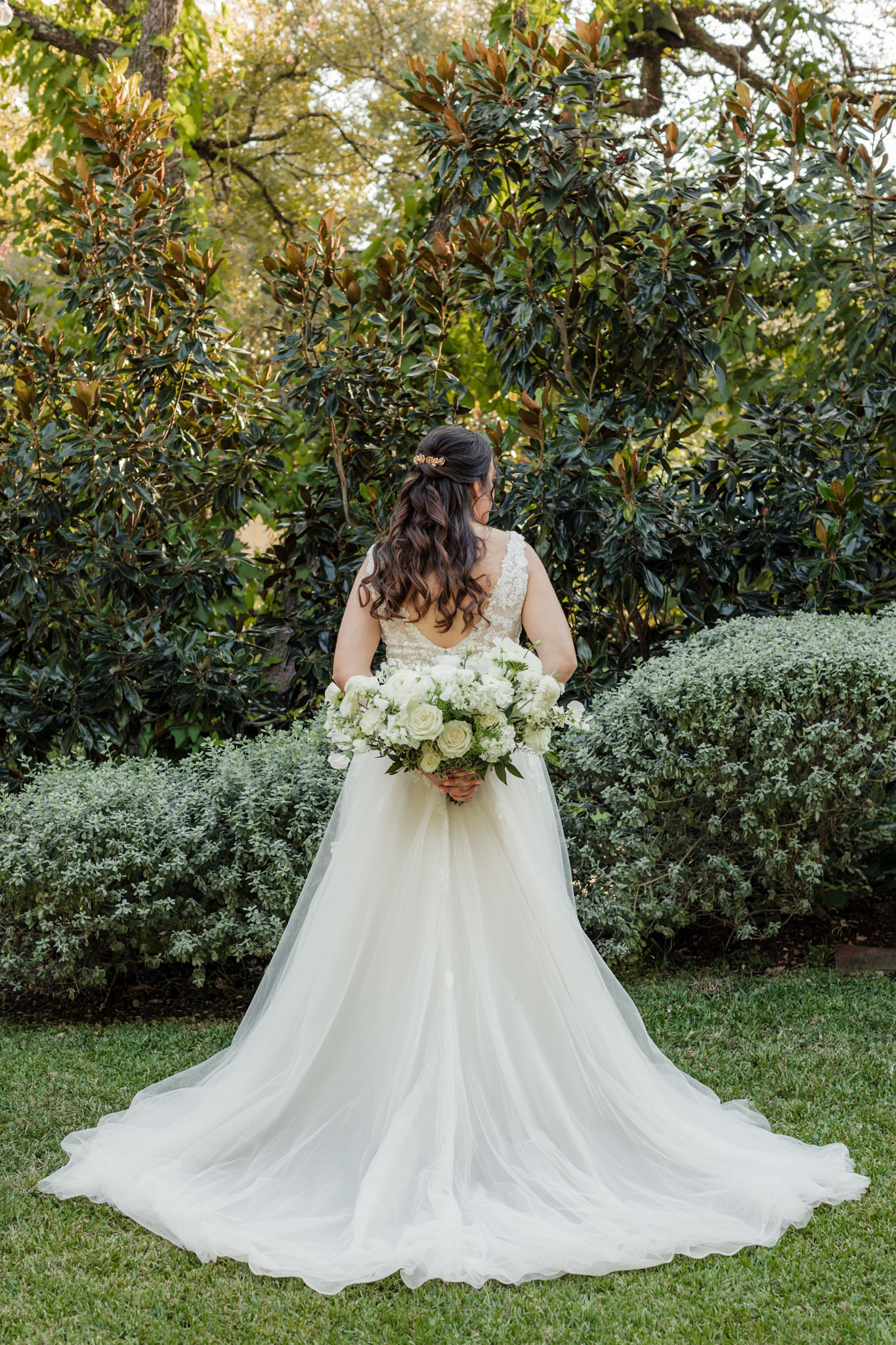 back of bride's dress with her bouquet