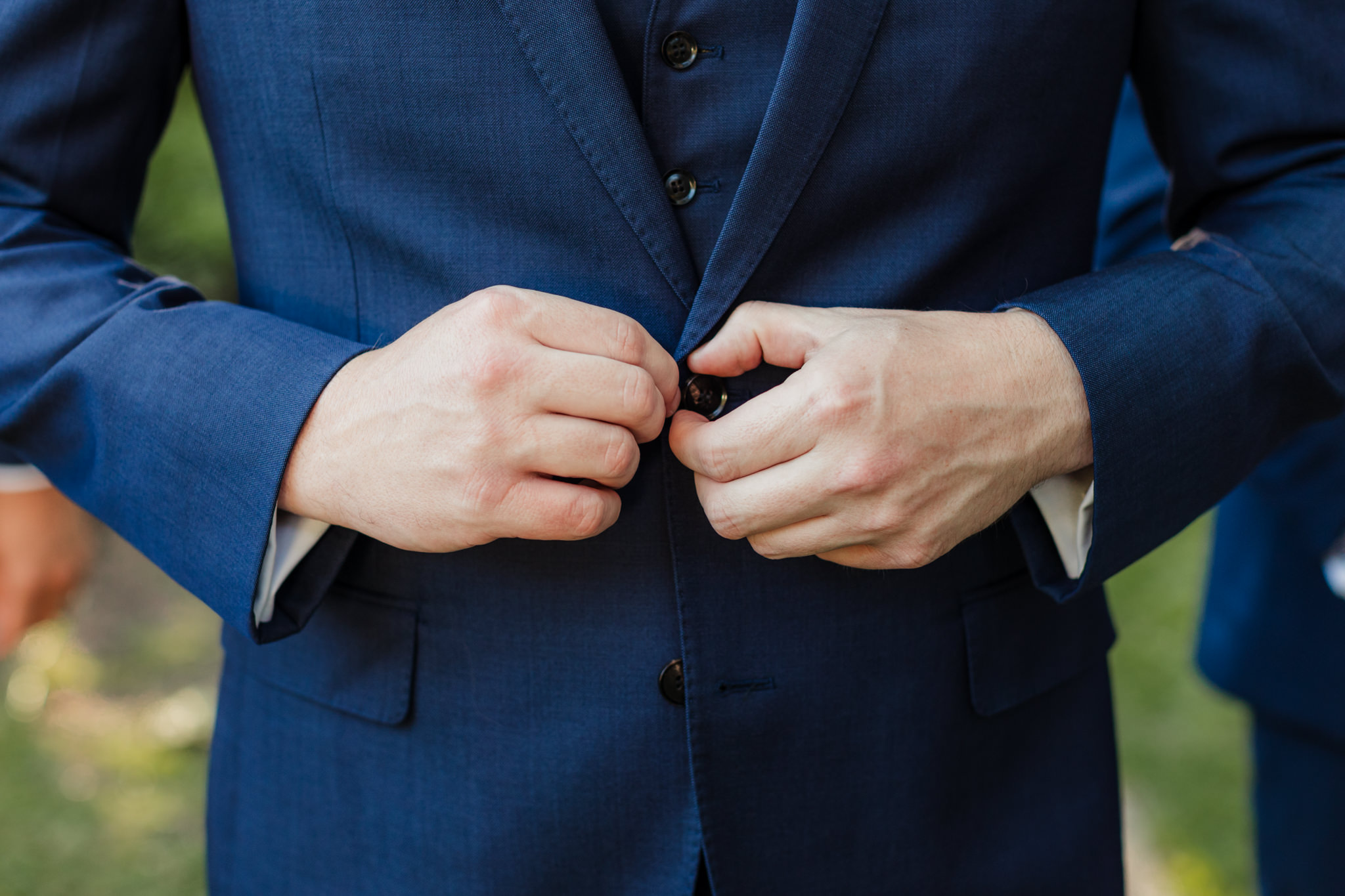 groom buttoning his suit