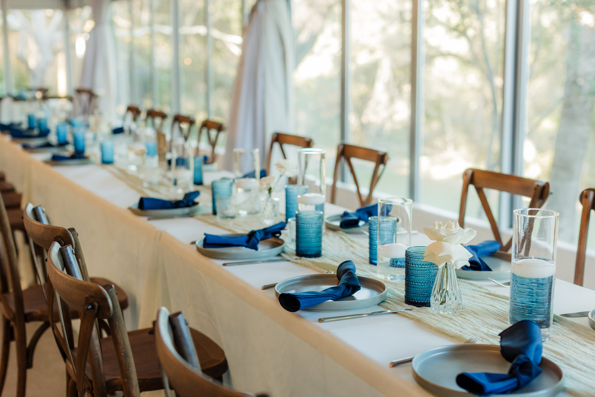 wedding head table with blue glasses and blue linens