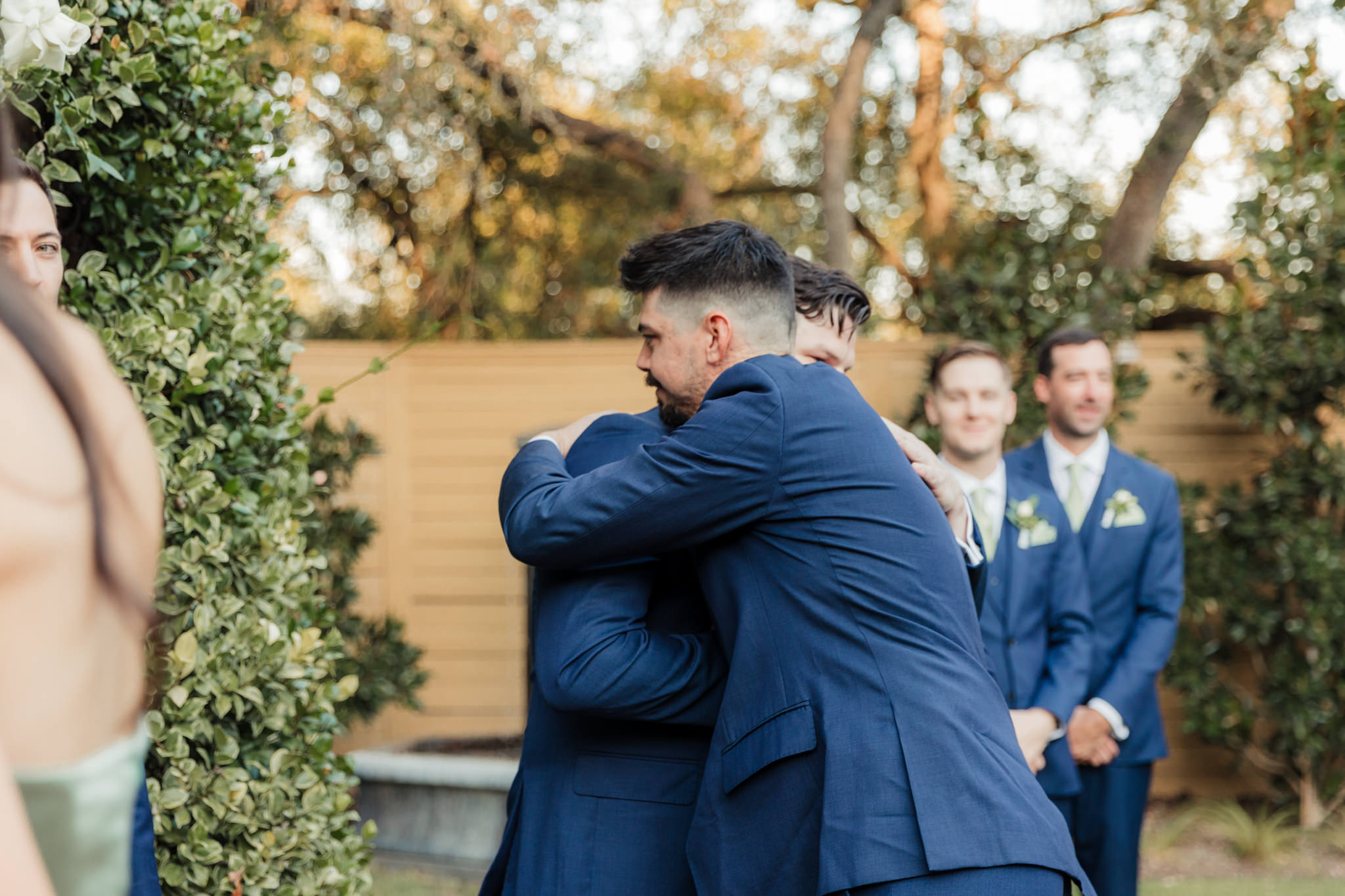 groom hugging groomsman