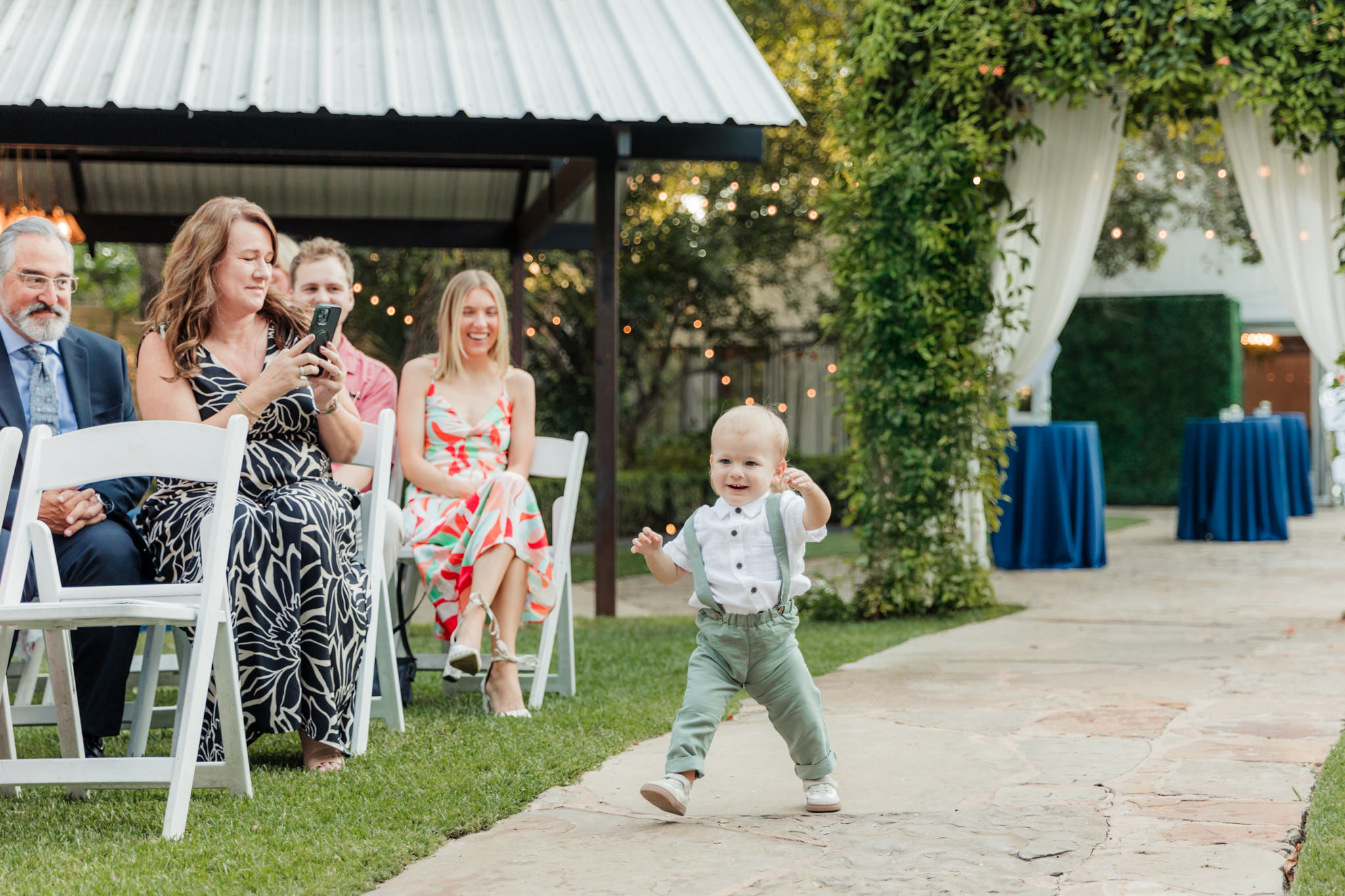 ring bearer walking up the aisle in overalls