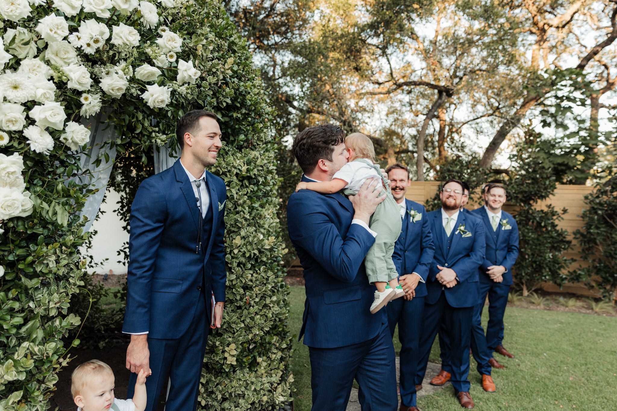 groom hugging his son at the end of the aisle