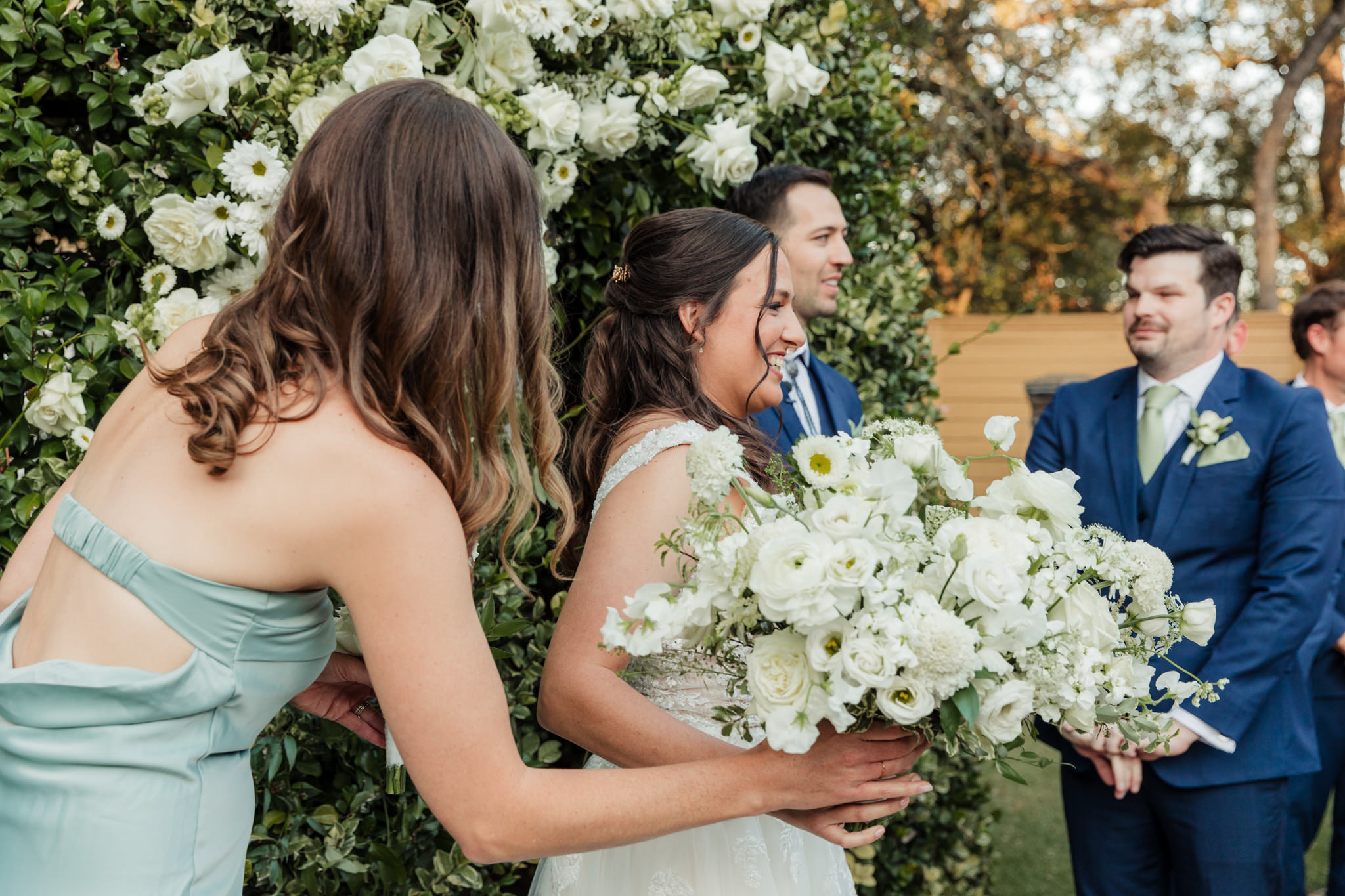 bride handing off her bouquet to maid of honor