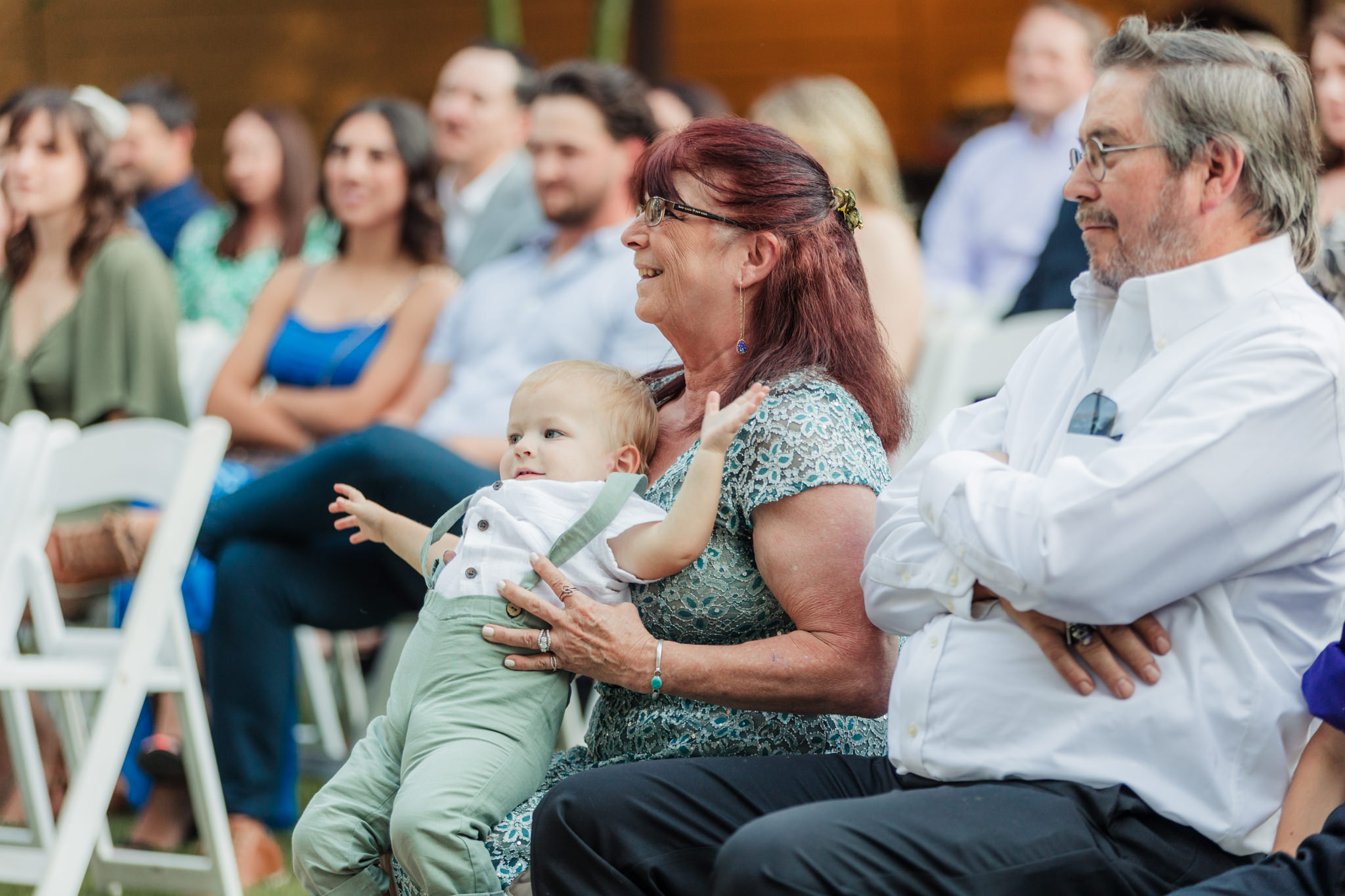 grandma holding ring bearer during ceremony