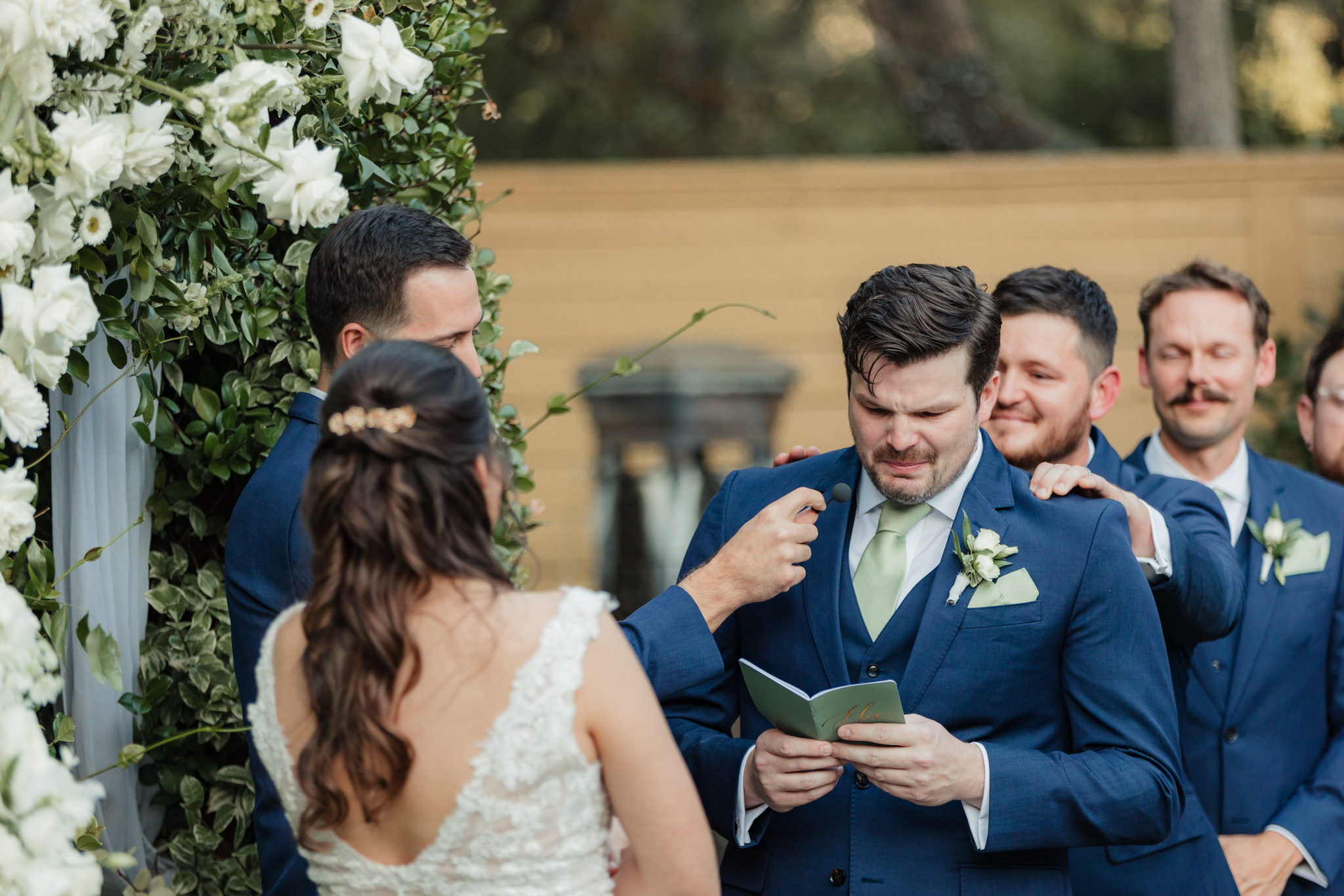 groom crying and getting comforted by groomsman