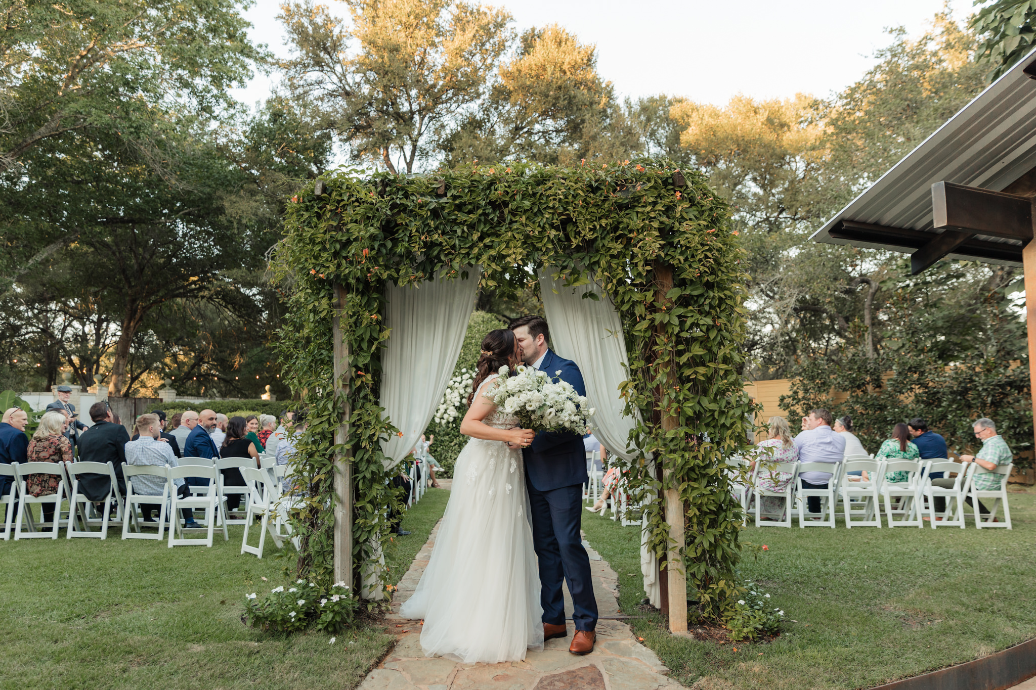 bride and groom kissing at the end of the aisle