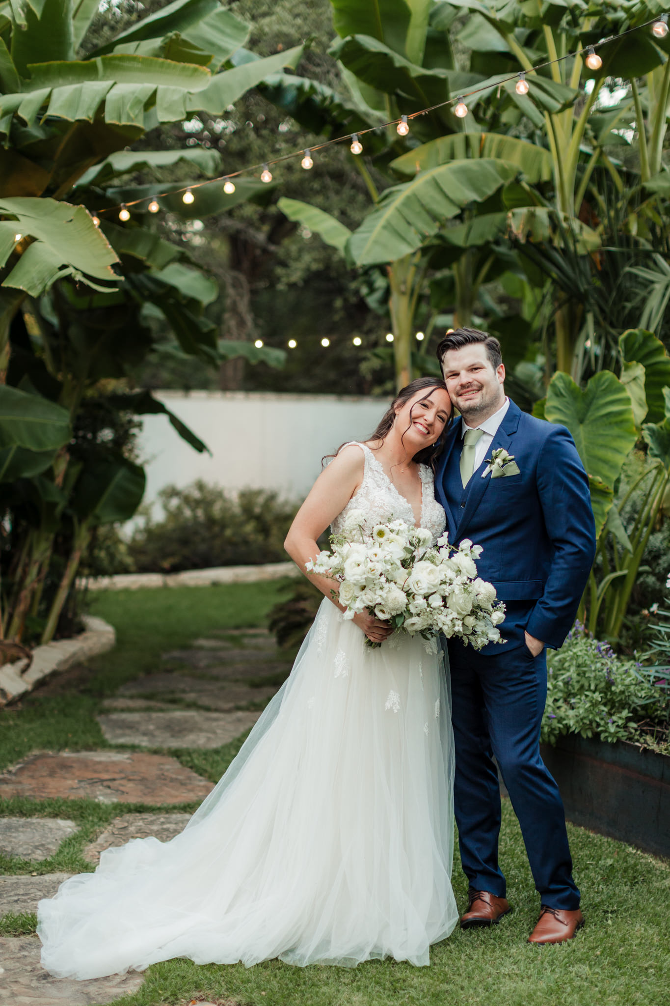 bride leaning on groom during portraits