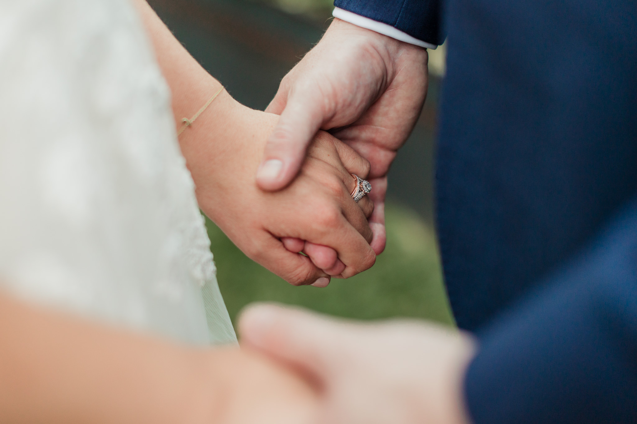 close up of bride's ring holding hands