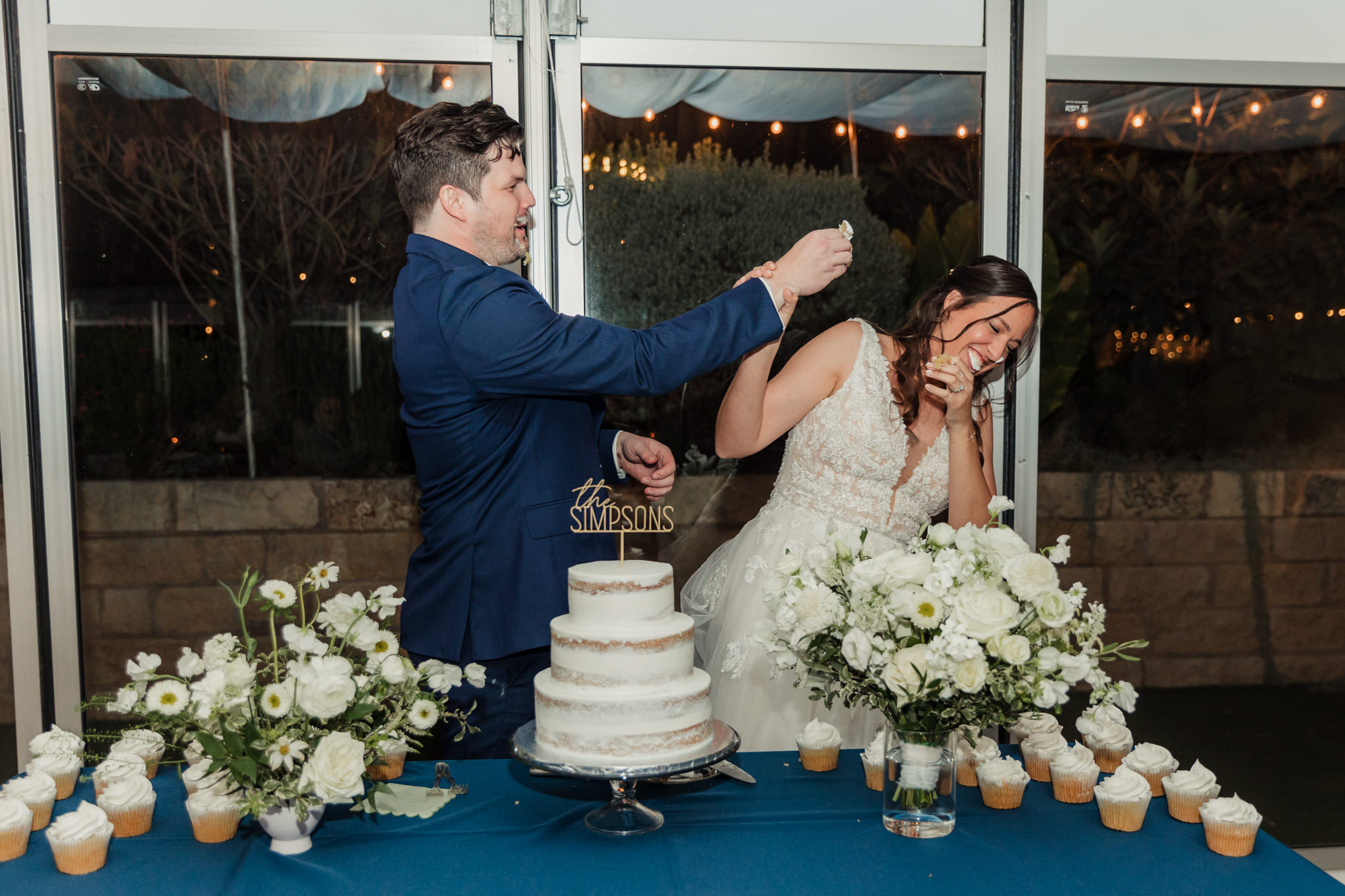 groom trying to put cake on bride