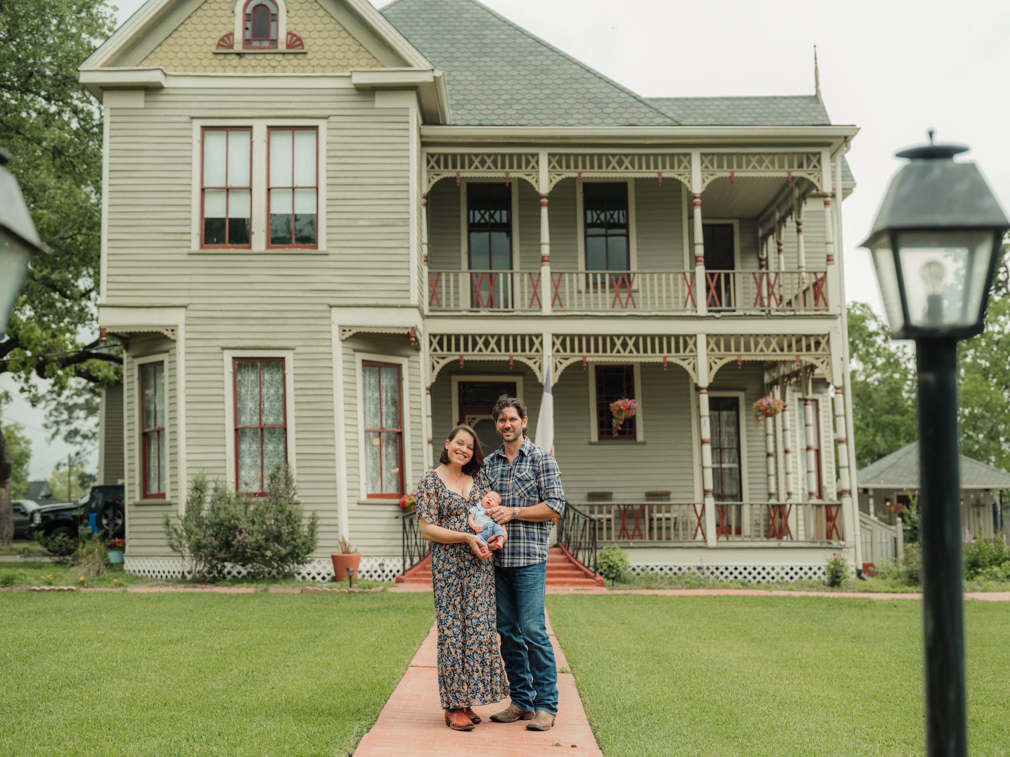 family standing in front of house with baby in the country